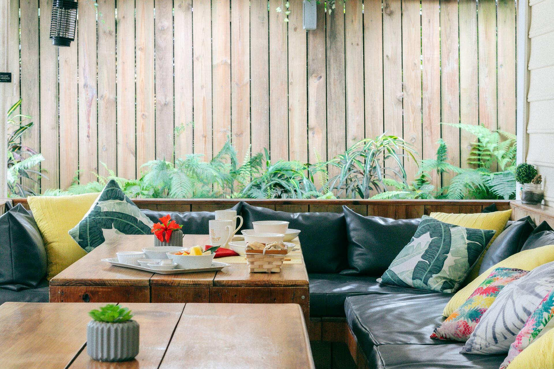 Timber tables and yellow chairs beside the planted courtyard